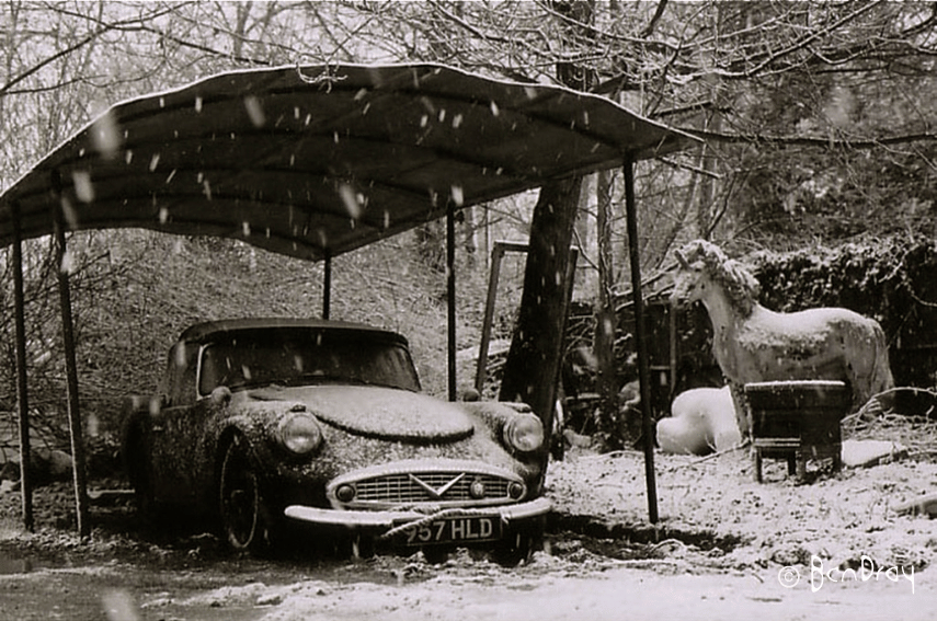 A vintage Daimler Dart car and prop unicorn sheltering from the snow in Shepperton.